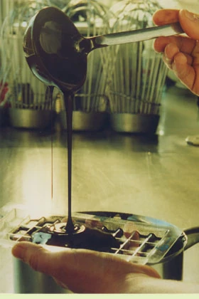 Handarbeit: Schokolade wird in Pralinenform gegossen
